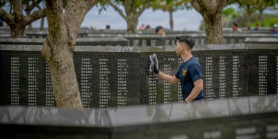 Hospital Corpsman 2nd Class Scott Chao, from Oakland, California, assigned to 3rd Medical Battalion, wipes down memorial walls during a cleanup effort hosted by the Japan Self-Defense Force at Peace Memorial Park in Itoman, Okinawa, Japan, June 13, 2026.
