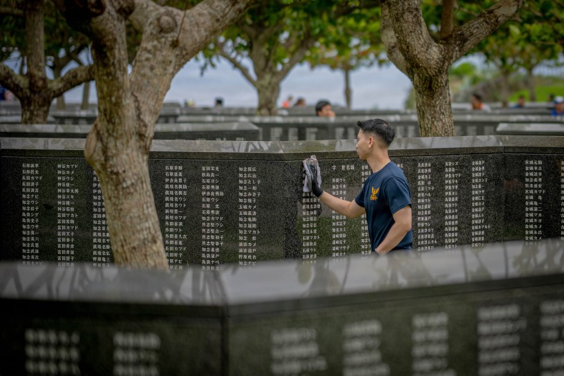 Hospital Corpsman 2nd Class Scott Chao, from Oakland, California, assigned to 3rd Medical Battalion, wipes down memorial walls during a cleanup effort hosted by the Japan Self-Defense Force at Peace Memorial Park in Itoman, Okinawa, Japan, June 13, 2026.