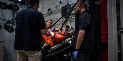An Air Force Research Laboratory team and NASA prepare a U.S. Air Force volunteer in the vertical deceleration tower at Wright-Patterson Air Force Base, Ohio, Nov. 3, 2023, to test the next replica of a space suit and seat for the Orion spacecraft.