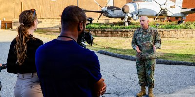116th Military Intelligence Brigade Commander Col. Matthew McGraw discusses the history of the brigade and evolution of Army Aerial Intelligence, Surveillance, and Reconnaissance (AISR) in front of the RC-12K Guardrail aircraft at Ft. Gordon, Georgia., on November 15, 2024.