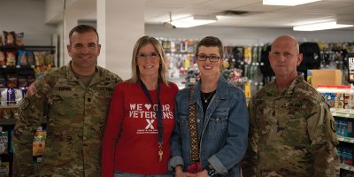Lt. Col. Christopher Vernon, Jenn Withers, Heather Felt, and Command Sgt. Maj. Jed Lundell gather for a group photo to commemorate the recognition of a life saving action. June 6th 2026, Camp Williams Troop Store.