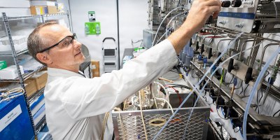 Matthew Yates, Ph.D., U.S. Naval Research Laboratory research scientist, adjusts the flow rate of gas for material generation in the mobile biomanufacturing system in Washington, D.C., June 23, 2026.