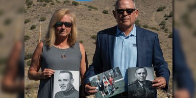 Retired U.S. Navy Cmdr. Douglas Murphy and his wife, Helen Murphy, hold momentos of Murphy’s late father in front of the Manzano Mountains at Kirtland Air Force Base, New Mexico, June 26, 2026. Douglas and Helen came to Kirtland to visit the Manzano Mountains, where his father, U.S. Army LTC Paul T. Murphy, died on a flight that crashed Sept. 14, 1977. (U.S. Air Force photo by Airman Maurice Casilla)