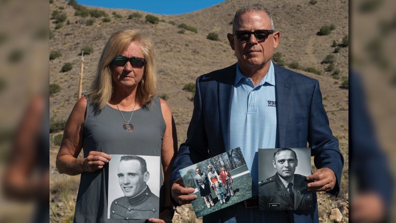Retired U.S. Navy Cmdr. Douglas Murphy and his wife, Helen Murphy, hold momentos of Murphy’s late father in front of the Manzano Mountains at Kirtland Air Force Base, New Mexico, June 26, 2026. Douglas and Helen came to Kirtland to visit the Manzano Mountains, where his father, U.S. Army LTC Paul T. Murphy, died on a flight that crashed Sept. 14, 1977. (U.S. Air Force photo by Airman Maurice Casilla)