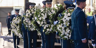 Senior Airman Christian Yokotake and fellow Airmen of the Blue Eagles Honor Guard, on behalf of “Torch 11” family members, prepare to attach wreaths to easels holding the images of the fallen B-52 aircrew.