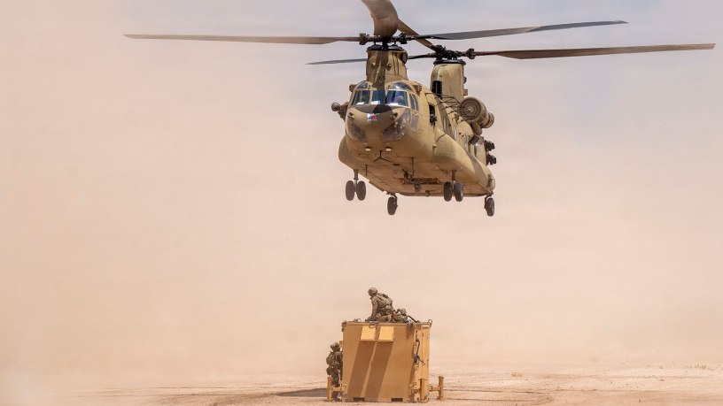 A U.S. Army CH-47 Chinook helicopter with the Combat Aviation Brigade, 1st Armored Division, assigned to Joint Task Force-Southern Border, hovers over a telecommunication network system during a sling load mission as part of Operation Muleskinner Trailblazer III in Big Bend, Texas, June 30, 2026.