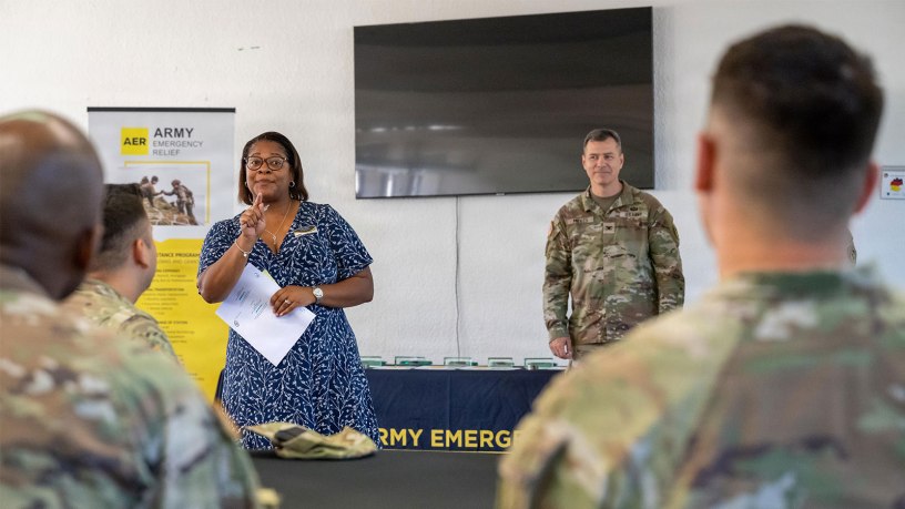 Briana Johnson, the Wiesbaden garrison's AER officer, stands together with Wiesbaden Garrison Commander Col. Ringo Midles, in front of Soldiers during the awards ceremony on July 1, 2026, to recognize top representatives and units for their Army Emergency Relief efforts.