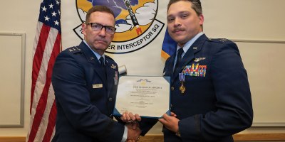 U.S. Air Force Lt. Gen. Robert Davis, commander, Alaskan North American Aerospace Defense Command Region, Alaskan Command,and Eleventh Air Force, left, presents Capt. Nathanial Welch, 18th Fighter Interceptor Squadron pilot and chief of plans and programs, with the Distinguished Flying Cross during a ceremony at Eielson Air Force Base, Alaska, July 1, 2026.