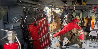 A G Company, 2-211th General Support Aviation Battalion, HH-60M Black Hawk crew chief hoists a hiker stranded on Matanuska Peak July 2, 2026. The rescue required the hoist-capable helicopter due to the vertical terrain. (Courtesy photo)