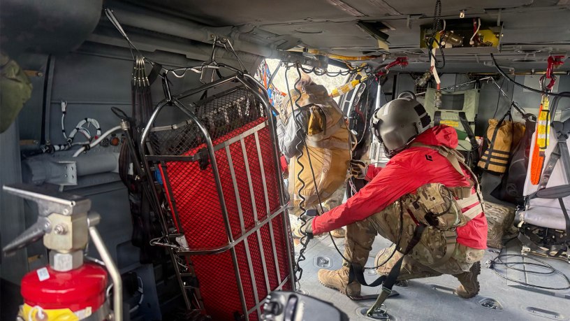 A G Company, 2-211th General Support Aviation Battalion, HH-60M Black Hawk crew chief hoists a hiker stranded on Matanuska Peak July 2, 2026. The rescue required the hoist-capable helicopter due to the vertical terrain. (Courtesy photo)