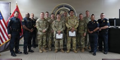 Clarksville Police Chief Ty Burdine, U.S. Army Sgt. Jacob Paz, and Sgt. Maisen Temple, pose for a group photo with officers from the Clarksville Police Department and leadership from the 101st Combat Aviation Brigade at the Clarksville Police Department Headquarters, June 24, 2026.