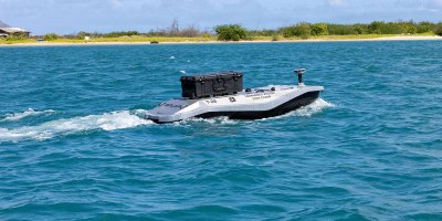 A digitally crewed surface vessel heads out to sea from Sand Island near Honolulu, Hawaii, to deliver parts for a 3D printer aboard Wasp-class amphibious assault ship USS Essex (LHD-2) during Exercise Rim of the Pacific 2026, July 7, 2026.