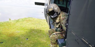 A UH-60 Black Hawk crew chief with the Louisiana National Guard's 1st Assault Battalion, 244th Aviation Regiment observes the marsh below while supporting a Christmas tree drop along the north shore of Lake Pontchartrain near Madisonville, Louisiana, July 8, 2026.