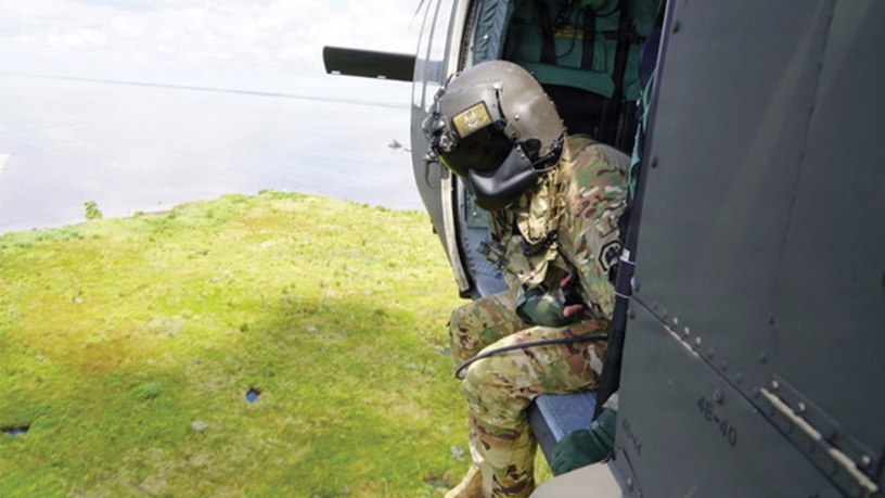 A UH-60 Black Hawk crew chief with the Louisiana National Guard's 1st Assault Battalion, 244th Aviation Regiment observes the marsh below while supporting a Christmas tree drop along the north shore of Lake Pontchartrain near Madisonville, Louisiana, July 8, 2026.