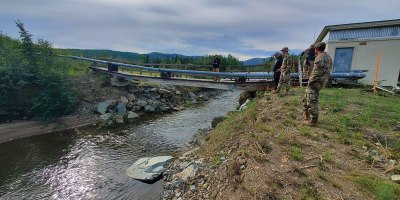 173rd Civil Engineering Squadron members work to fix the sole water line during Operation 26-02 Indian Mountain, at Indian Mountain Long Range Radar Station, in Alaska, July 9, 2026. Fixing the bridge ensured proper sanitation and fire suppression for the nearby facility. (U.S. Air National Guard Courtesy Photo)