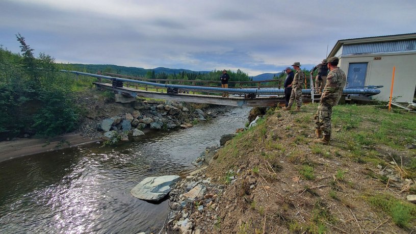 173rd Civil Engineering Squadron members work to fix the sole water line during Operation 26-02 Indian Mountain, at Indian Mountain Long Range Radar Station, in Alaska, July 9, 2026. Fixing the bridge ensured proper sanitation and fire suppression for the nearby facility. (U.S. Air National Guard Courtesy Photo)