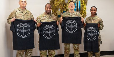 U.S. Air Force Senior Master Sgt. Kevin Johnson, Master Sgt. Ernest Brown, Chief Warrant Officer 2 Jonathan Miller and Tech. Sgt. Staci Starks-Miller, graduates of the Air Force Train, Advise, Coach Officer program and future Warrant Officer Training School cadre members, pose for a photo following their graduation at Maxwell Air Force Base, Alabama, July 15, 2026.