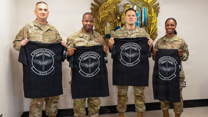 U.S. Air Force Senior Master Sgt. Kevin Johnson, Master Sgt. Ernest Brown, Chief Warrant Officer 2 Jonathan Miller and Tech. Sgt. Staci Starks-Miller, graduates of the Air Force Train, Advise, Coach Officer program and future Warrant Officer Training School cadre members, pose for a photo following their graduation at Maxwell Air Force Base, Alabama, July 15, 2026.