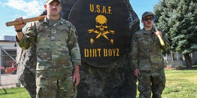 U.S. Air Force Tech. Sgt. Reuben Kruger and Senior Airman Joshua Workman, 366th Civil Engineer Squadron pavement and construction equipment operators, pose for a photo in front of a "Dirt Boyz" sign at Mountain Home Air Force Base, Idaho, July 14, 2026.
