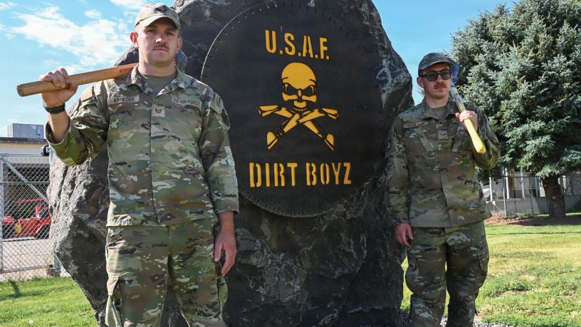U.S. Air Force Tech. Sgt. Reuben Kruger and Senior Airman Joshua Workman, 366th Civil Engineer Squadron pavement and construction equipment operators, pose for a photo in front of a "Dirt Boyz" sign at Mountain Home Air Force Base, Idaho, July 14, 2026.