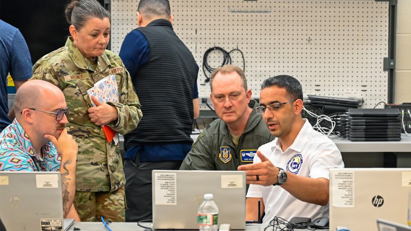 U.S. Air Force Staff Sgt. Marwan AlSaeedi, 439th Communications Squadron client services technician, explains the cyber assessments he conducted to Col. Christopher Holland, 439th Airlift Wing commander, and Chief Master Sgt. Kristen M. Maloney, 439th Airlift Wing command chief at the Cyber Chicopee Innovative Readiness Training program in Chicopee, Mass., July 21, 2026.