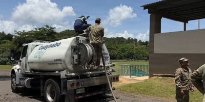 U.S. Army soldiers work alongside a civilian contractor atop a Guaynabo City municipal water tanker truck (K-210SS) during a water distribution operation at an unidentified facility in Puerto Rico.