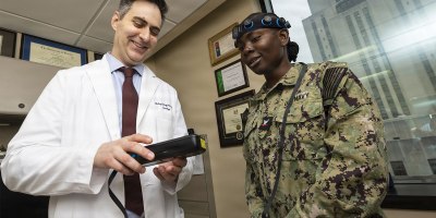 U.S. Army Maj. Zachary S. Davey, a neurologist at Walter Reed National Military Medical Center, reviews data from a point-of-care EEG system with U.S. Navy Hospital Corpsman 3rd Class Tulisa Reeves during a technology demonstration, Bethesda, Md., July 8, 2026.