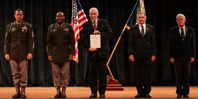 Dr. David Williamson (center), medical director of the Inpatient Brain Injury/Neuropsychiatry and RAPTOR programs, and Neuropsychiatry Service chief at Walter Reed receives recognition as an honorary member of the elite 75th Ranger Regiment, headquartered at Fort Benning, Georgia, during a ceremony there on June 24.