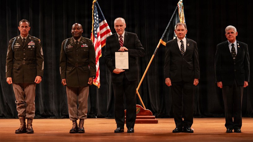Dr. David Williamson (center), medical director of the Inpatient Brain Injury/Neuropsychiatry and RAPTOR programs, and Neuropsychiatry Service chief at Walter Reed receives recognition as an honorary member of the elite 75th Ranger Regiment, headquartered at Fort Benning, Georgia, during a ceremony there on June 24.