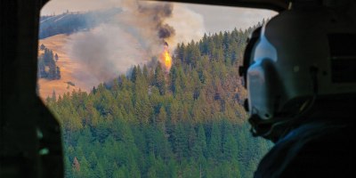 Skyler Merritt, a Cal Fire helicopter manager, looks out from an Oregon Army National Guard CH-47 Chinook helicopter as it approaches the Hagen Fire near Pendleton, Ore., July 29, 2026.