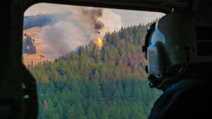 Skyler Merritt, a Cal Fire helicopter manager, looks out from an Oregon Army National Guard CH-47 Chinook helicopter as it approaches the Hagen Fire near Pendleton, Ore., July 29, 2026.