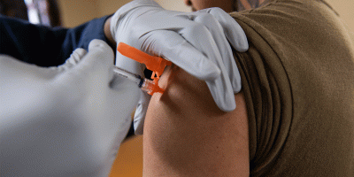 Logistics Specialist Seaman Frenys Hechavarria, from West Palm Beach, Florida, is administered an influenza vaccination by Hospital Corpsman 2nd Class Adam Collins, from Chicago, on a barge assigned to USS Ronald Reagan (CVN 76) at Naval Base Kitsap in Bremerton, Washington, Oct. 21, 2025.