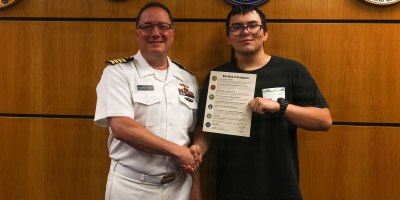 Capt. Rich Sussman, commanding officer of Commander, Navy Regional Maintenance Center, poses for a photo with his son, Future Sailor Matthew Sussman, at Albany Military Entrance Processing Station following an Oath of Enlistment ceremony. The occasion marked a unique intersection of career milestones for the family, as Sussman concluded his 35-year Navy career the same day his son shipped to bootcamp.