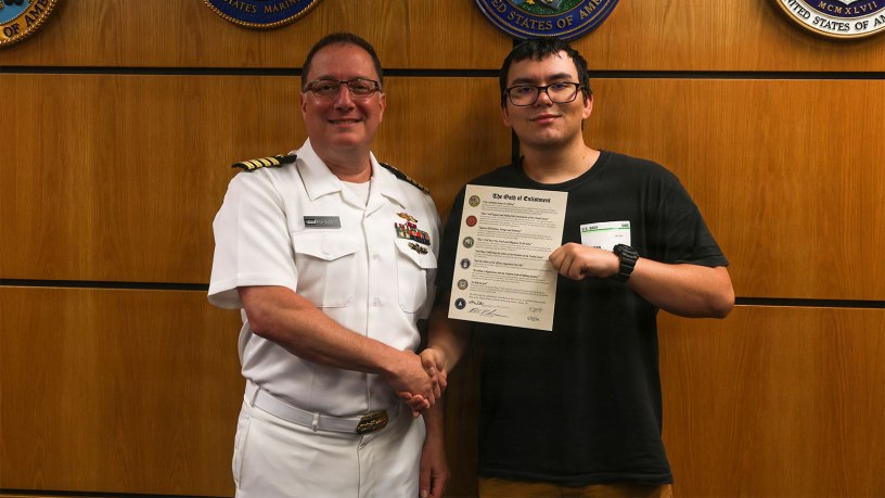 Capt. Rich Sussman, commanding officer of Commander, Navy Regional Maintenance Center, poses for a photo with his son, Future Sailor Matthew Sussman, at Albany Military Entrance Processing Station following an Oath of Enlistment ceremony. The occasion marked a unique intersection of career milestones for the family, as Sussman concluded his 35-year Navy career the same day his son shipped to bootcamp.