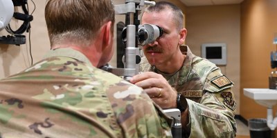 U.S. Air Force Capt. Max Sarver, right, Luke Medical Group Operational Medical Readiness Squadron optometry element chief, performs an eye exam at Luke Air Force Base, Arizona, July 29, 2026.
