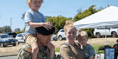 U.S. Air Force Capt. Maxwell Laguna, left, 60th Security Forces Squadron deputy commander, and his family celebrate the 2026 National Night Out at Travis Air Force Base, California, Aug. 4, 2026. The event invited Travis AFB residents to enjoy family-friendly festivities. (U.S. Air Force photo by Airman Zayd Anderson)