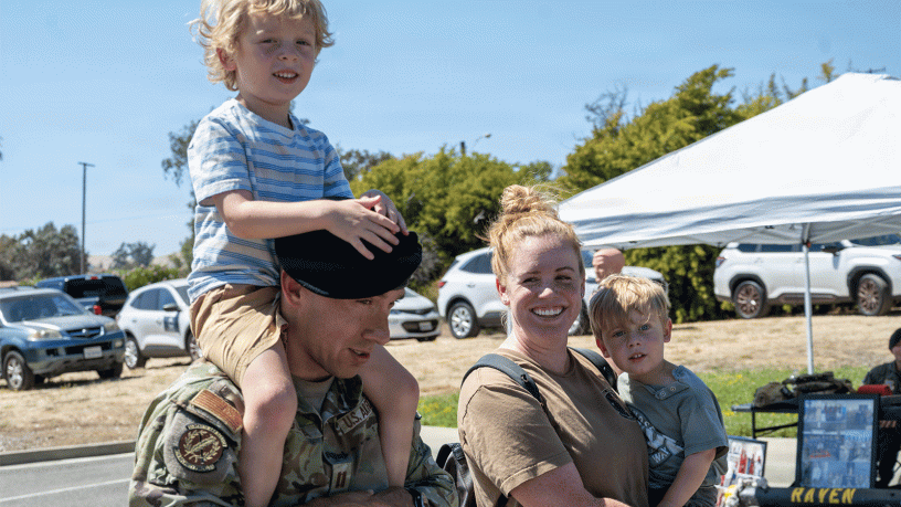 U.S. Air Force Capt. Maxwell Laguna, left, 60th Security Forces Squadron deputy commander, and his family celebrate the 2026 National Night Out at Travis Air Force Base, California, Aug. 4, 2026. The event invited Travis AFB residents to enjoy family-friendly festivities. (U.S. Air Force photo by Airman Zayd Anderson)