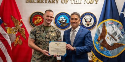 Acting Secretary of the Navy Hung Cao presents Chaplain Derek M. Henson, Headquarters Marine Corps Religious Operations Officer, Office of the Chaplain of the Marine Corps, with the Navy and Marine Corps Commendation Medal during a ceremony at the Pentagon in Arlington, Virginia, Aug. 4, 2026.