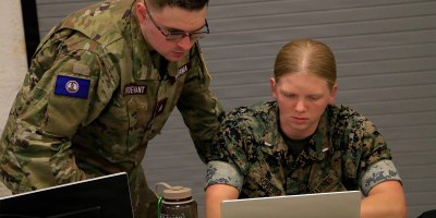 A U.S. Marine and Virginia Defense Force member simulate the process they would follow to respond to and mitigate a cyber attack Aug. 5, 2026, during Cyber Fortress 26 at the State Military Reservation in Virginia Beach, Virginia.