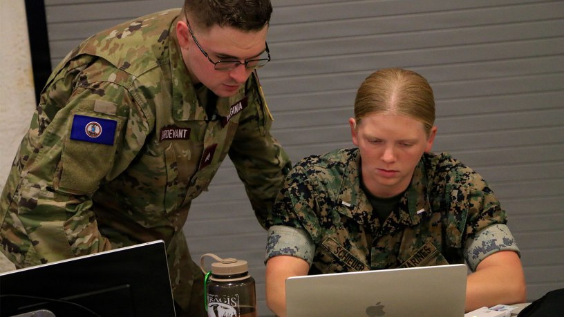 A U.S. Marine and Virginia Defense Force member simulate the process they would follow to respond to and mitigate a cyber attack Aug. 5, 2026, during Cyber Fortress 26 at the State Military Reservation in Virginia Beach, Virginia.