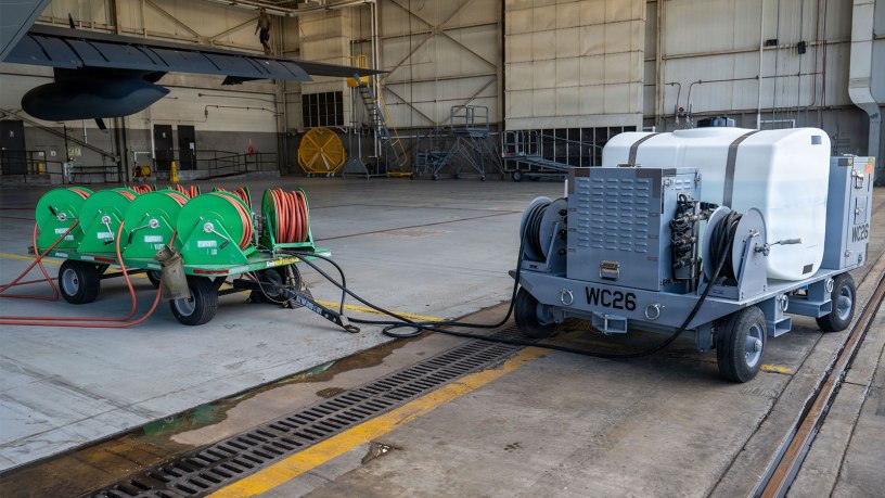 An Airman-designed aircraft engine compressor wash cart is connected to an AC-130J Ghostrider assigned to the 1st Special Operations Wing at Hurlburt Field, Florida, Aug. 6, 2026. The upgraded cart enables maintainers to wash all four engines in a single cycle, reducing standard wash times by 75% and reducing overall ground maintenance hours. (U.S. Air Force photo by Airman Olivia Perkins)