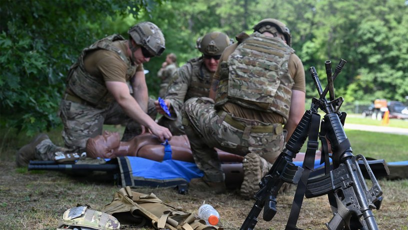 Weapons rest in a stack as Airmen from the Explosive Ordinance Disposal (EOD) provide Tactical Combat Casualty Care (TCCC) to a simulated patient at Barnes Air National Guard Base, Westfield, Mass., August 20, 2026.