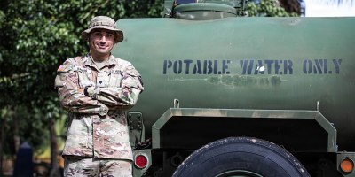 U.S. Army Spc. Jesús D. Ramos, a water treatment specialist assigned to the 105th Quartermaster Water Purification and Distribution Company, 191st Regional Support Group, Puerto Rico Army National Guard, stands beside a potable-water tanker at a water purification site in Canóvanas, Puerto Rico, Aug. 20, 2026.