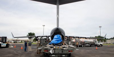 U.S. Air Force service members from the 21st Airlift Squadron and the 621st Contingency Response Wing, assigned to Travis Air Force Base, California, along with Panamanian partners prepare to load an irradiator into a C-17 Globemaster III in Panama Pacifico, Panama, Aug. 23, 2026.