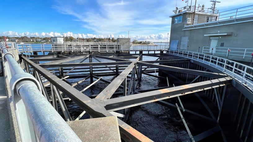 This photograph captures the New Bedford Hurricane Protection Barrier with its elevated walkway and structural framework overlooking the water. The facility is part of the U.S. Army Corps of Engineers infrastructure designed to protect the city from storm surges.