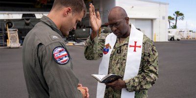 U.S. Navy Chaplain Father Mark Bristol, prays over Lt.j.g. Gunnar Brodfuehrer, a MH-60T Jayhawk helicopter pilot assigned to Coast Guard Air Station Barber's Point in Kapolei, Hawaii, July 15, 2026.