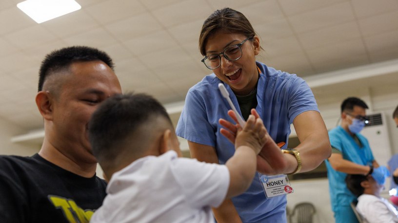 U.S. Navy Petty Officer 3rd Class Honey Diaz, a dental corpsman assigned to 1st Dental Battalion, 1st Marine Logistics Group, encourages a child during Exercise Koa Moana 2026 in Koror, Palau, Aug. 7, 2026.