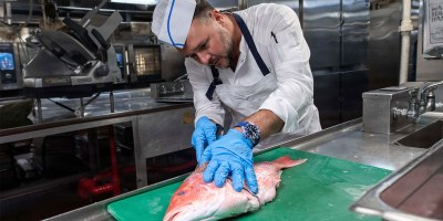 Chef Adam Sobel filets a fish in the galley of Nimitz-class aircraft carrier USS Theodore Roosevelt (CVN 71), Sep. 4, 2026.