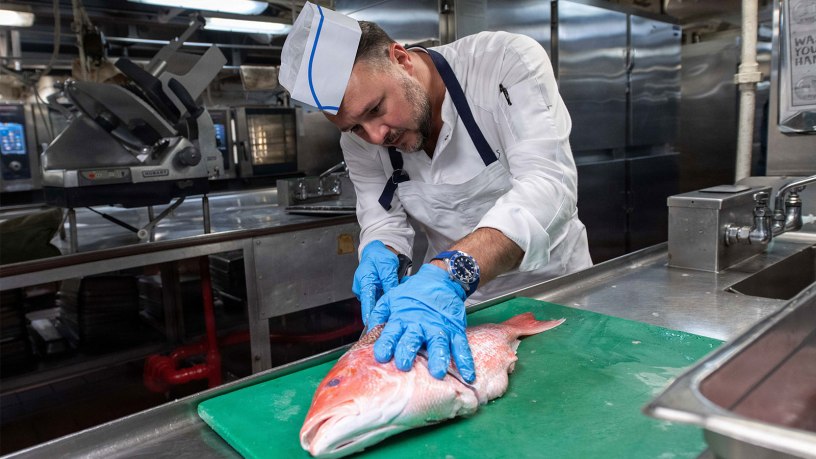 Chef Adam Sobel filets a fish in the galley of Nimitz-class aircraft carrier USS Theodore Roosevelt (CVN 71), Sep. 4, 2026.