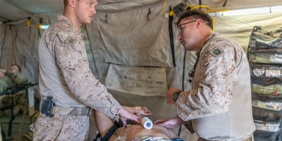 Hospital Corpsman 1st Class Troy Holton, left, and Hospital Corpsman 3rd Class Maxim Allenson, both with the 8th Engineer Support Battalion, attached to Combat Logistics Battalion 7, 1st Marine Logistics Group, assigned to Joint Task Force-Southern Border in support of Operation Ardent Vanguard, provide simulated emergency medical treatment to a mock casualty in a field aid station during casualty evacuation training in Naco, Ariz., August 28, 2026.